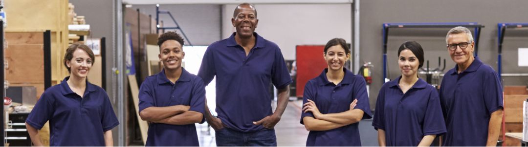 a group of workers inside a warehouse smiling at the point of capture